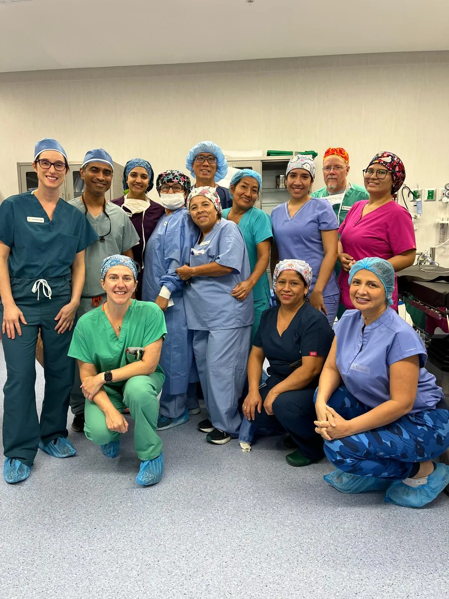 Members of a surgical project team gather in clinical attire.