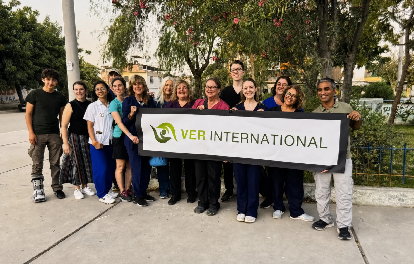 VER volunteers and clinical partners gather outdoors with a VER International banner.